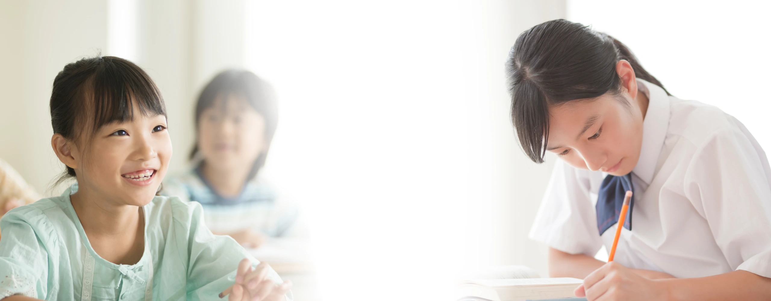 授業を楽しむ小学生とノートに集中する高校生の姿。個別学習ゆうあい塾の安心できる学びの場を表現したメインビジュアル(PC用)。